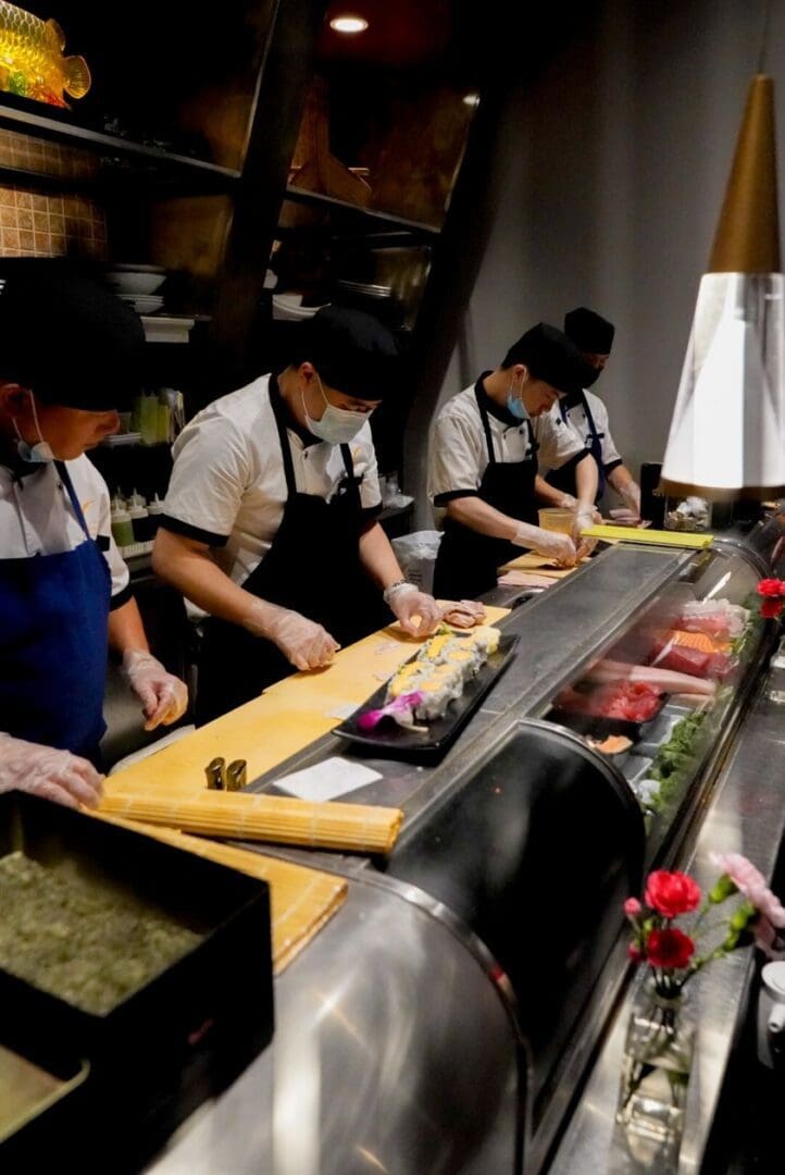 A group of people in aprons preparing food.
