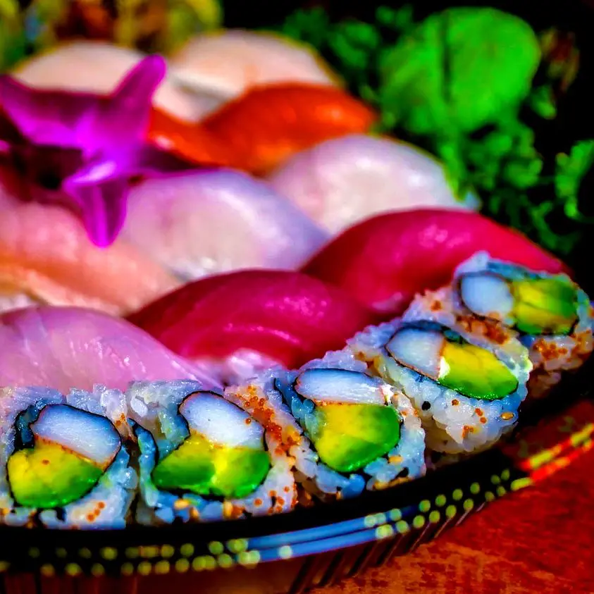 A plate of sushi with colorful fish and seaweed.